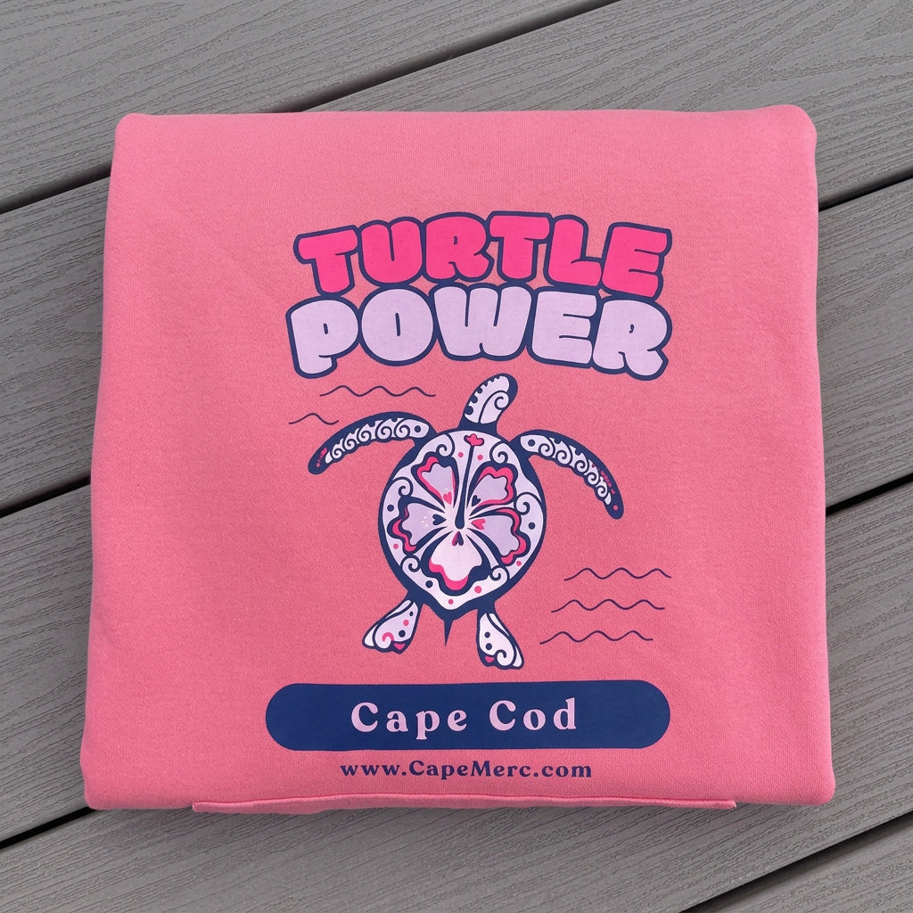 Pink hoodie featuring a sea turtle graphic, supporting Cape Cod cold-stunned turtle rescue efforts.