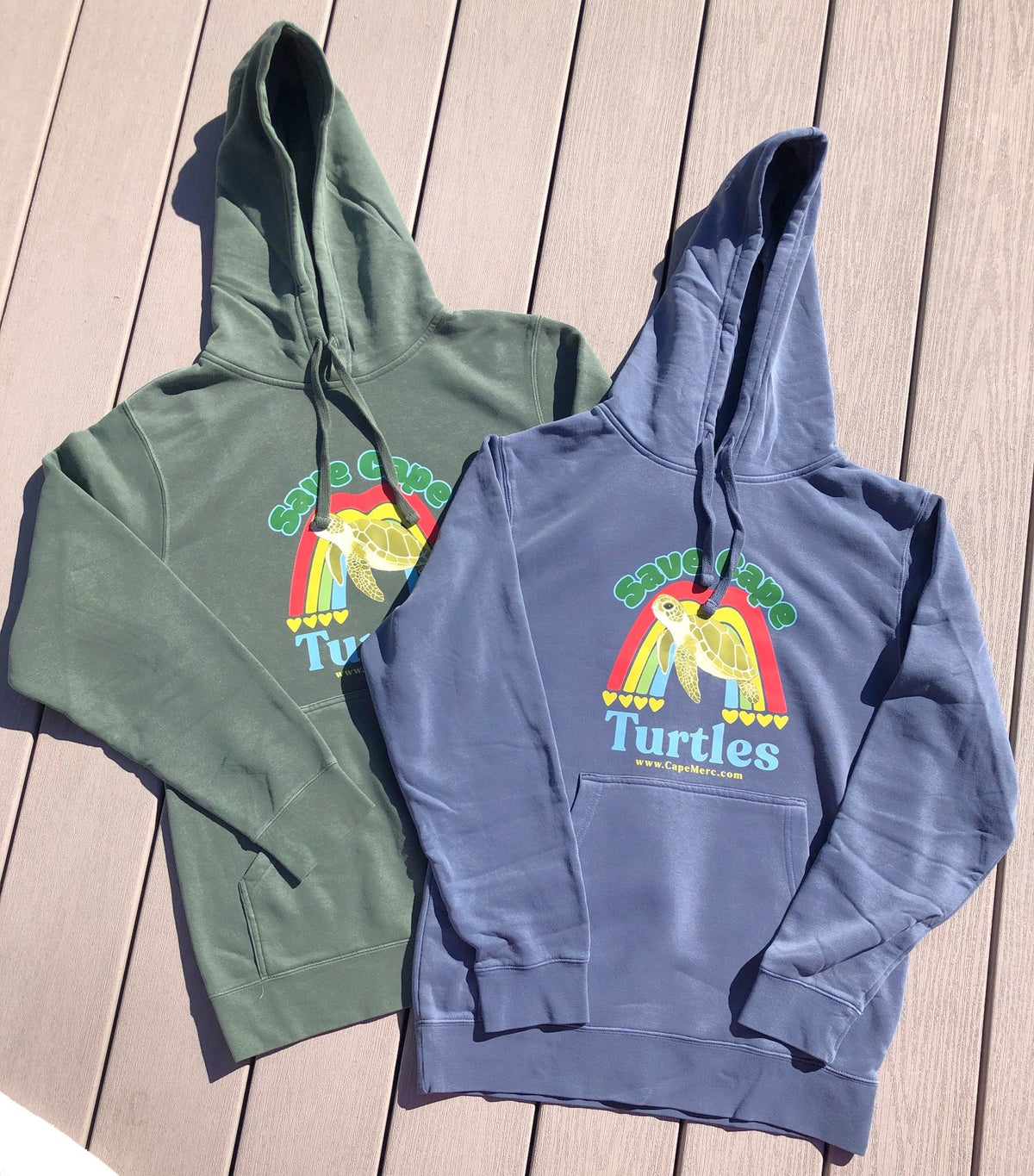 Flat lay view of two Save Cape Turtles hoodie sweatshirts that support Cape Cod cold-stunned sea turtle rescue.