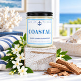 Candle labeled 'Coastal' on a wooden block with a wooden background