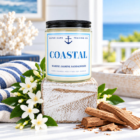 Candle labeled 'Coastal' on a wooden block with a wooden background