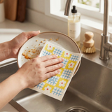 A reusable Ripple Cloth being used to wash a ceramic dish inside a kitchen sink, demonstrating how the eco friendly household cloth replaces disposable sponges and paper towels to help oceans.