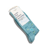 A pair of organic cotton sea turtle protection socks wrapped in their eco-friendly retail packaging sleeve.