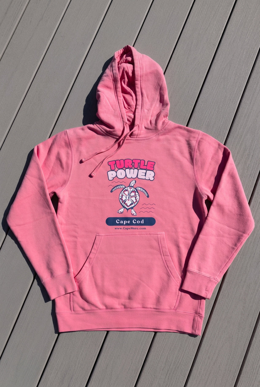 Flat lay view of the pink Turtle Power hoodie sweatshirt that supports Cape Cod cold-stunned sea turtle rescue.