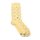Flat lay of yellow smiley face organic cotton socks that support mental health awareness.